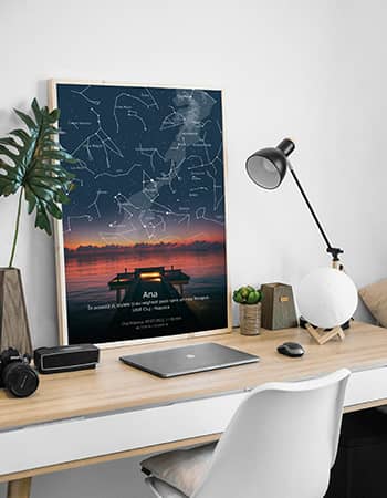 Tablou personalizat cu harta cerului si apus spectaculos, asezat pe un birou modern cu lampa, laptop si decor minimalist. Posterul include numele „Ana” si un mesaj emotionant. Ideal pentru cadou inspirational sau decor de birou cu semnificatie personala.